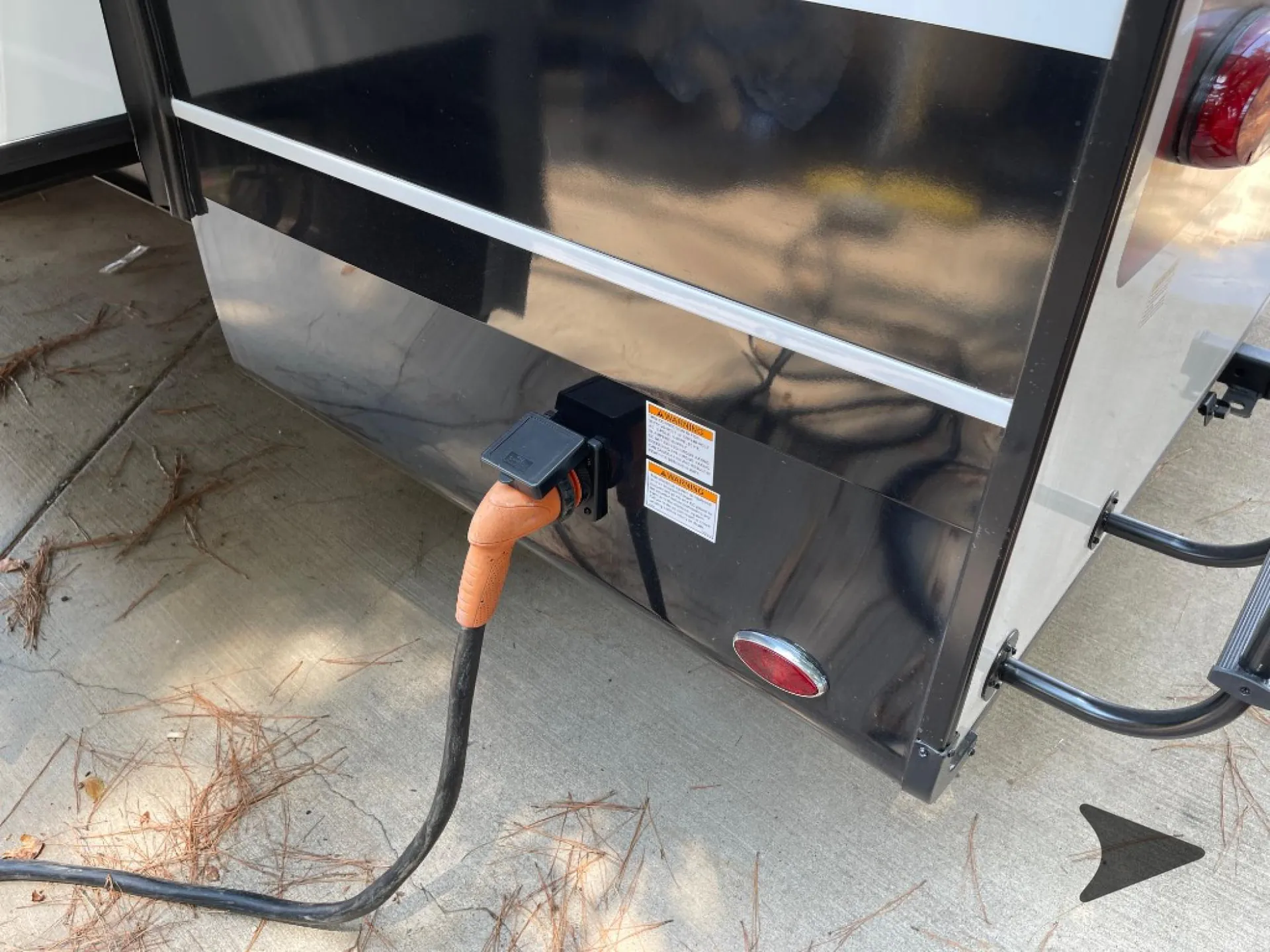 2026 Jayco North Point 377RLBH — Exterior close-up visibly shows the RV's shore-power electrical connection and warning labels