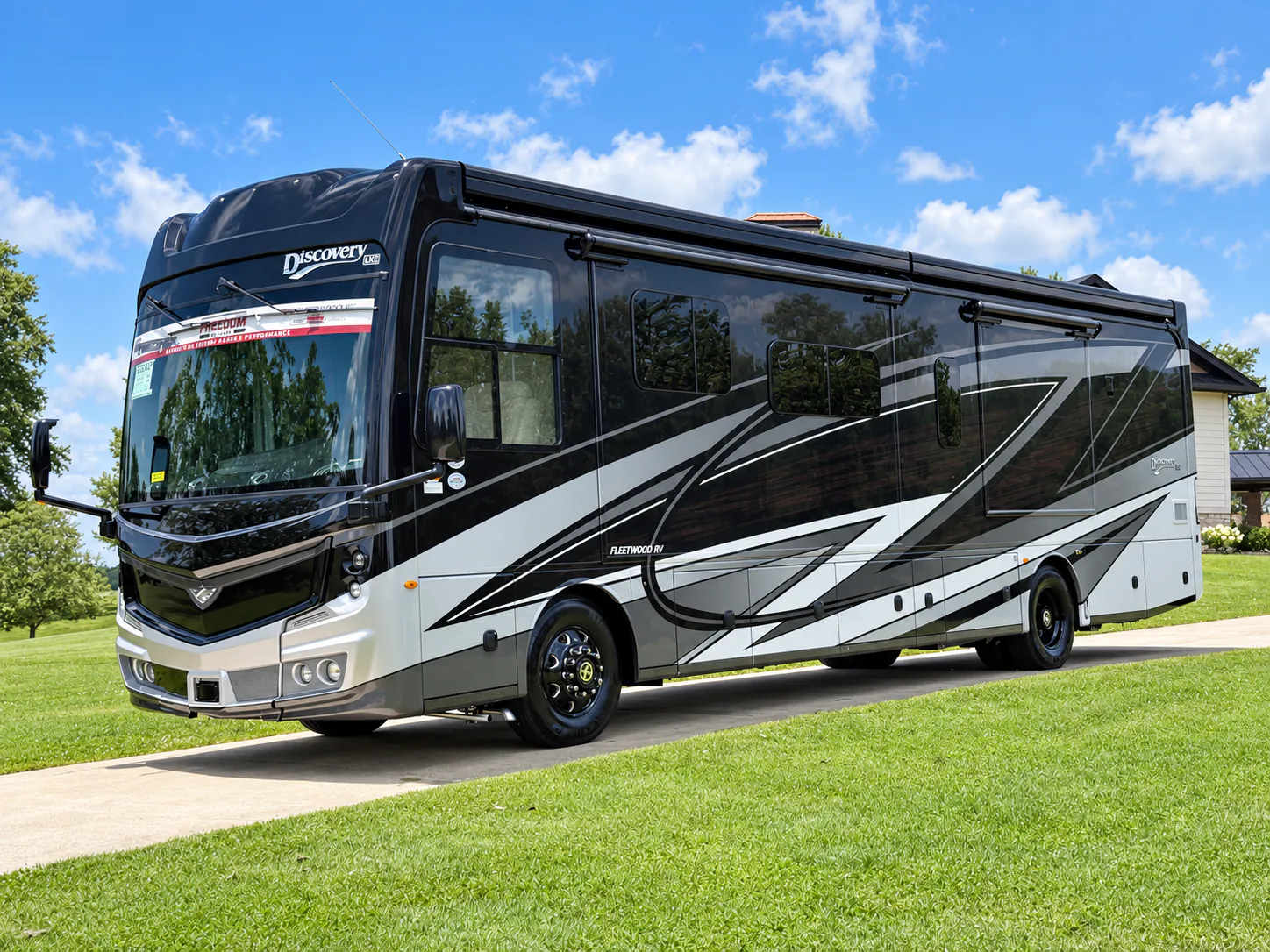 2027 Fleetwood Discovery LXE 40M — Front three-quarter photograph visibly shows the exterior front cap, windshield, mirrors, wheels, and side body