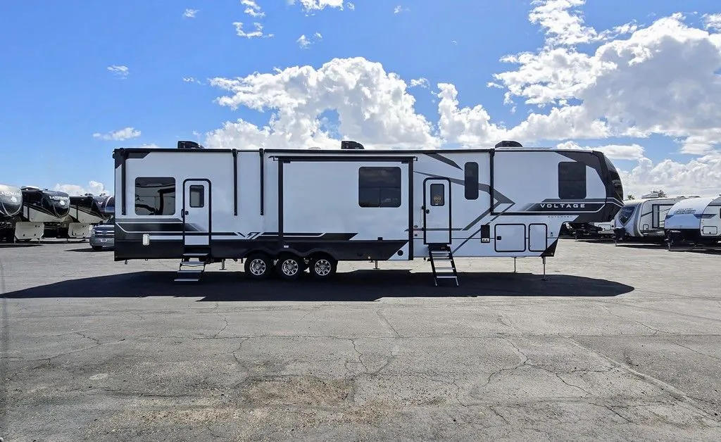 2025 Dutchmen Voltage 4225 — Full exterior side photograph of the Voltage fifth-wheel RV, including shell, wheels, slides, hitch area, and awning hardware