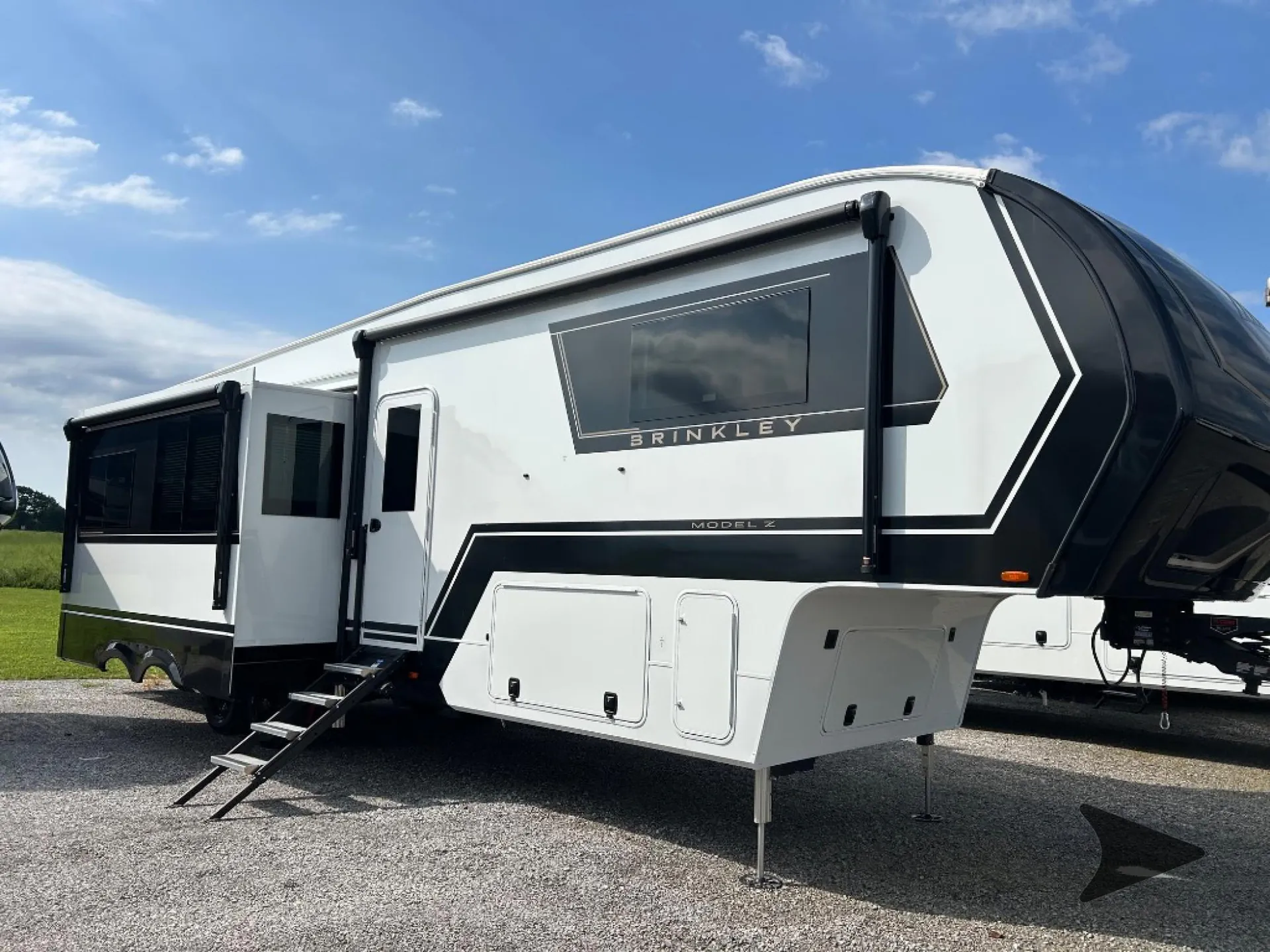 2026 Brinkley Model Z 3515 — Photograph clearly shows the outside side/front of a fifth-wheel RV, including shell, slide-out, awning, hitch area, and landing legs