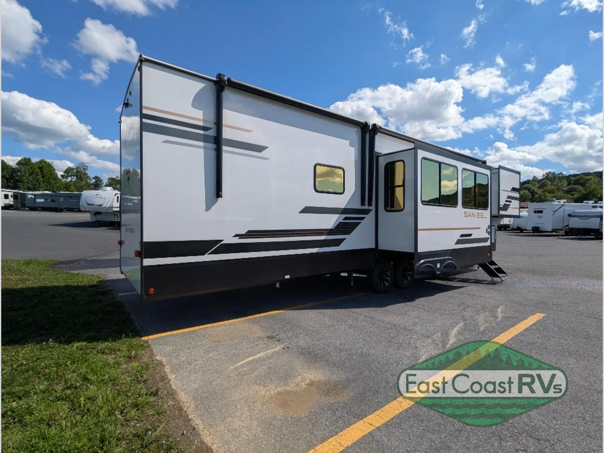 2027 Forest River Sanibel 40BUNK — The rear and opposite exterior side of the fifth-wheel RV, including slide-outs and wheels