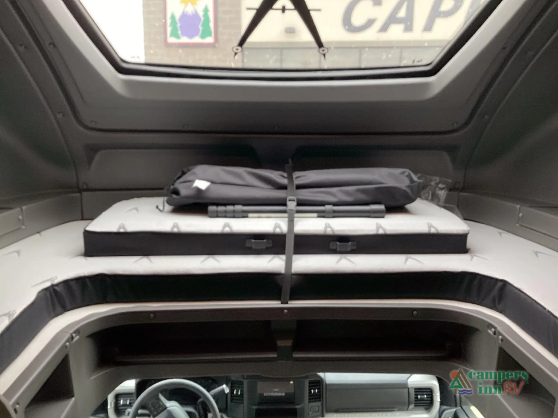 2027 Grand Design Lineage Series F 31ZW — Over-cab sleeping loft with strapped mattress and skylight above the visible driver cockpit