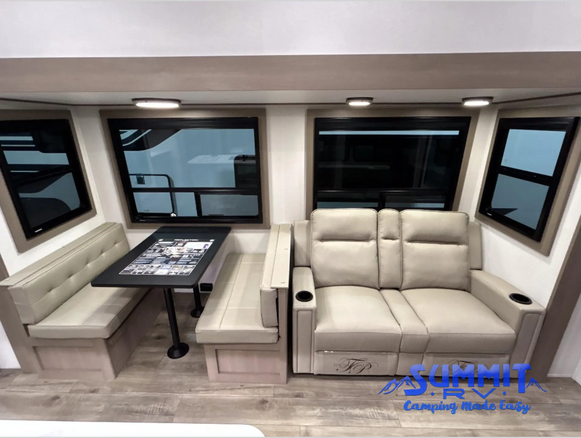 2027 Grand Design Reflection 362TBS — Fifth wheel living area with theater recliners beside a booth dinette, table, windows, and built-in seating