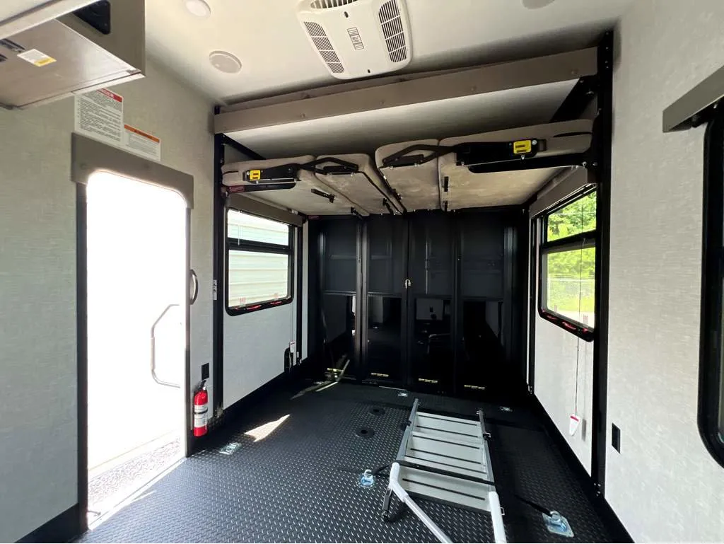 2025 Jayco Seismic Luxury Series 4113 — Toy-hauler garage with broad textured cargo floor, tie-downs, ramp equipment, and folded overhead furnishings