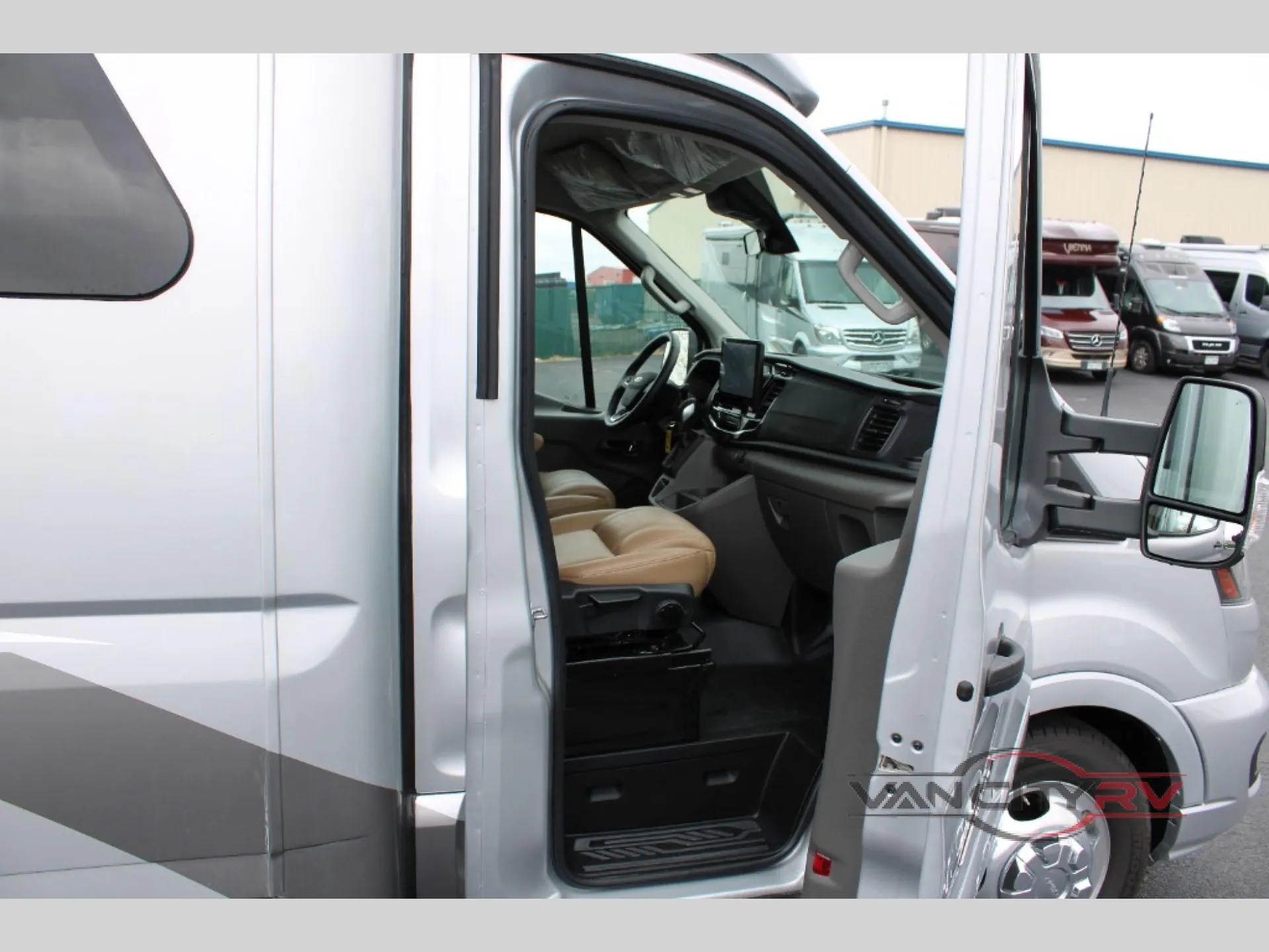 2025 Chinook RV Maverick SS — Open front cab shows the steering wheel, dashboard, two tan seats, and passenger-side entry