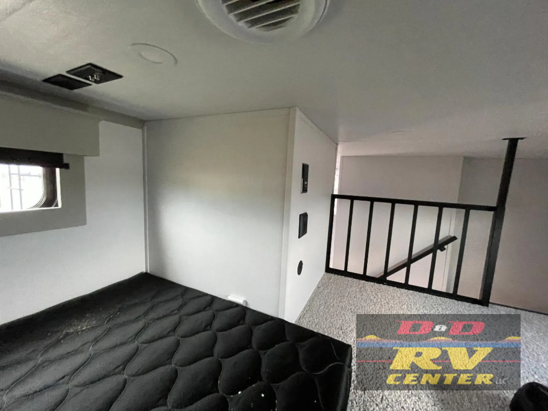 2026 Keystone Montana High Country 377FL — Over-cab loft mattress with carpeted sleeping platform, railing, wall outlets, and a nearby window