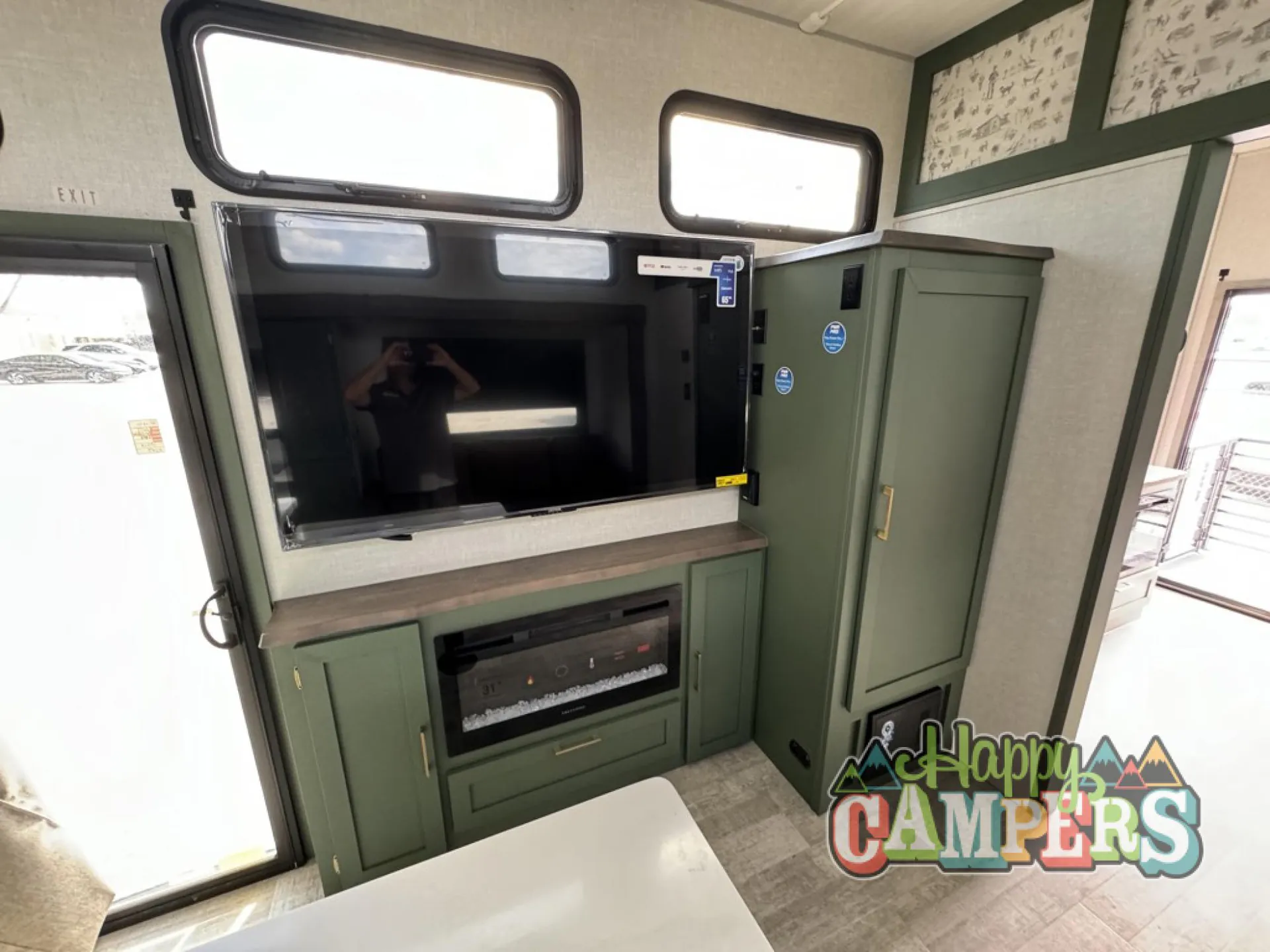 2025 Forest River IBEX RVS3 — Living entertainment wall with television, fireplace, media cabinetry, and adjacent tall storage cabinet