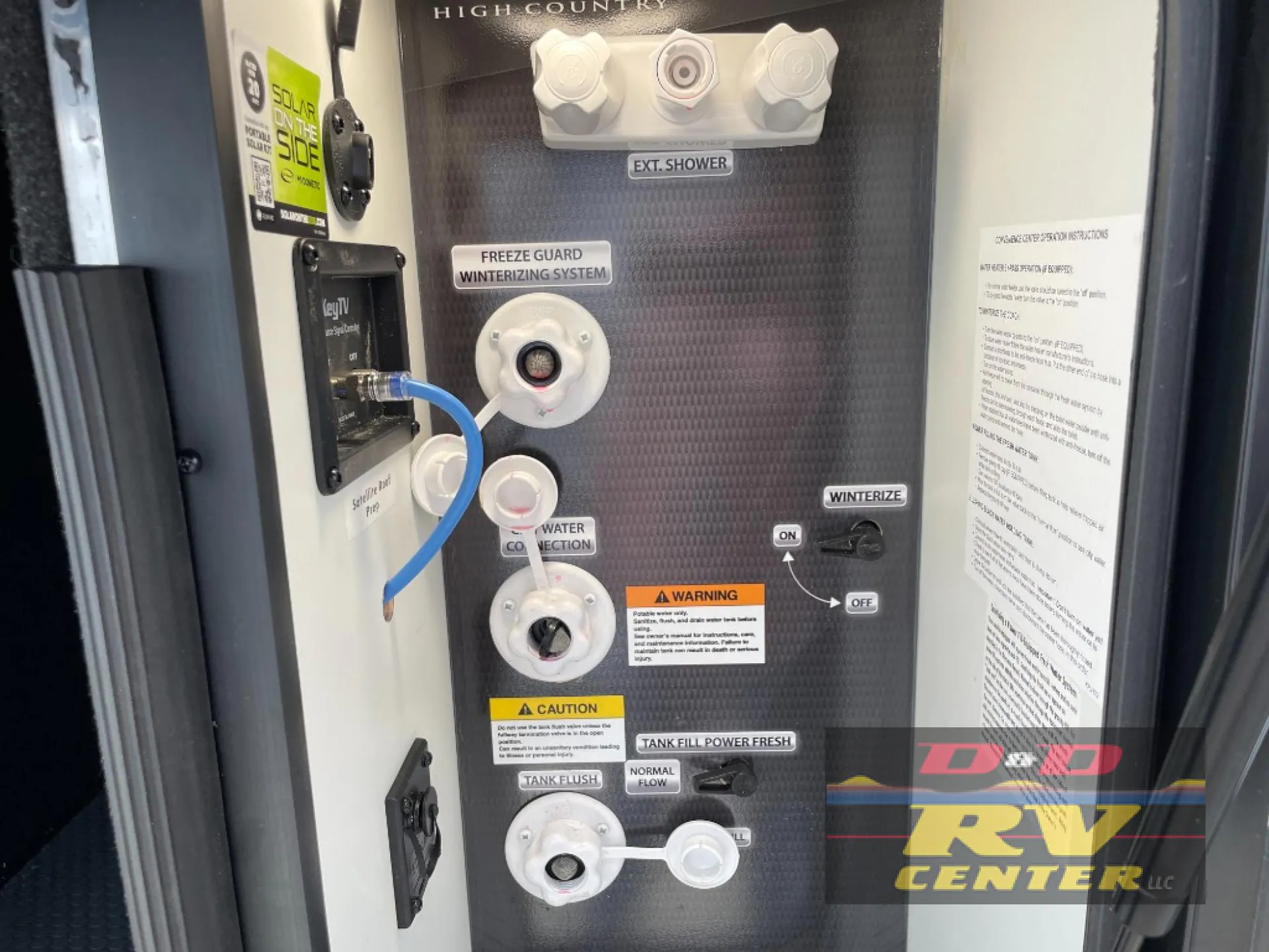 2026 Keystone Montana High Country 377FL — Exterior utility panel visibly shows water connections, winterizing controls, fresh-tank controls, and an exterior shower
