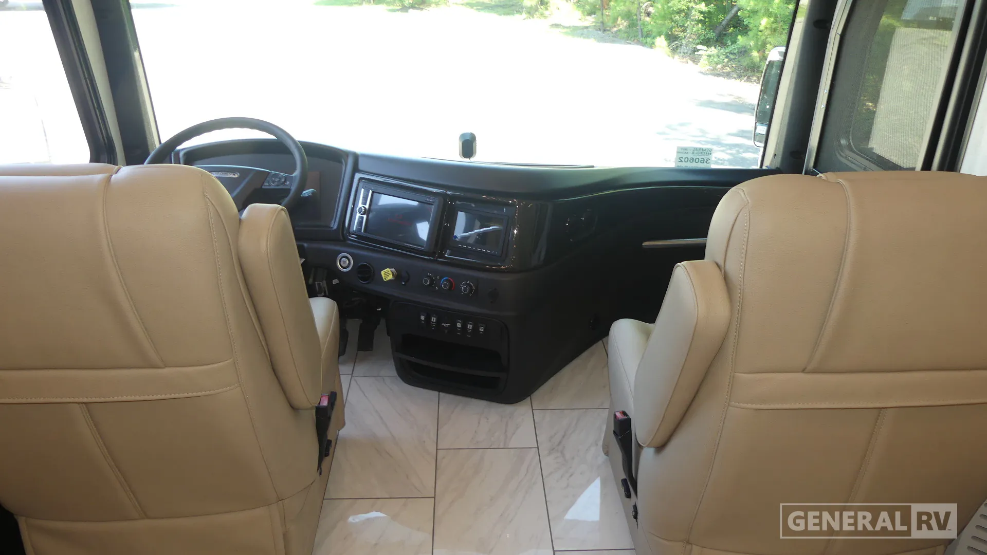 2027 Fleetwood Discovery LXE 40M — Class A cockpit with steering wheel, dashboard displays, controls, captain’s seats, and forward windshield