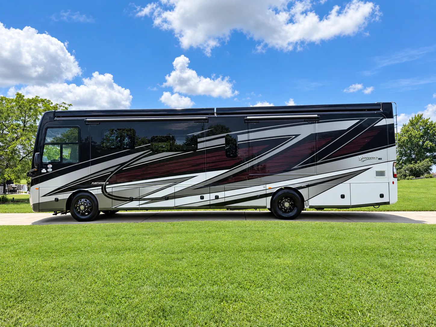 2027 Fleetwood Discovery LXE 40M — Full side photograph visibly shows the outside of the motorhome with exterior windows, awnings, wheels, and compartments