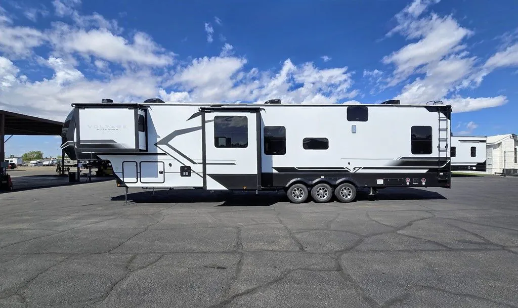 2025 Dutchmen Voltage 4225 — Full side exterior photograph visibly shows the RV shell, windows, slide-out, and triple-axle wheels