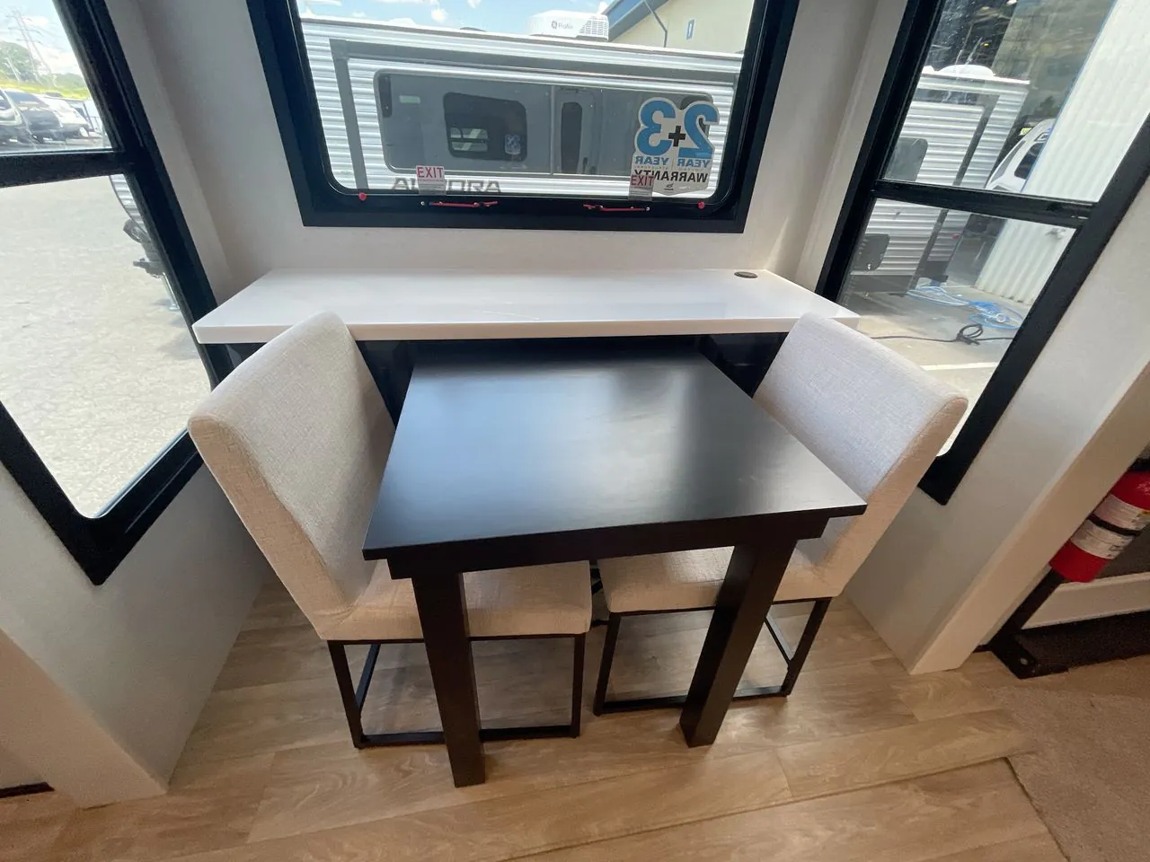 2027 Jayco Pinnacle 39FLOK — Freestanding dining table with two upholstered chairs, a bench seat, and surrounding windows