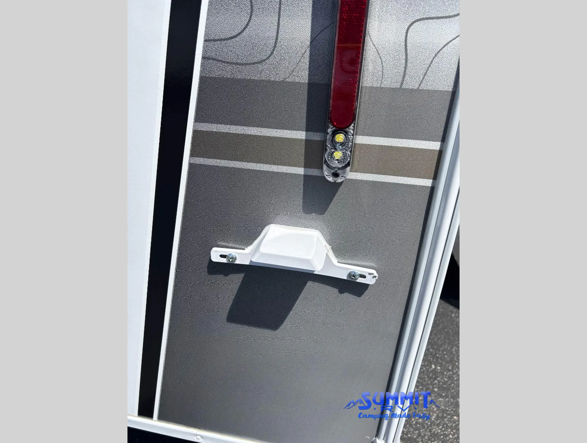2027 Jayco Eagle 355MBQS — Close photograph of an exterior-installed RV light and grab handle on the outer wall