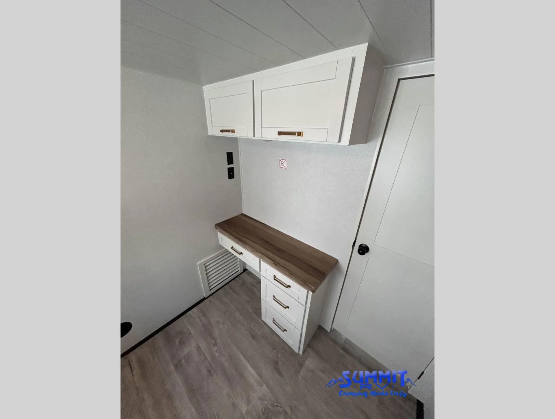 2027 Jayco Eagle 355MBQS — Empty built-in cabinet and countertop workspace with drawers, overhead cupboards, and a lower ventilation grille