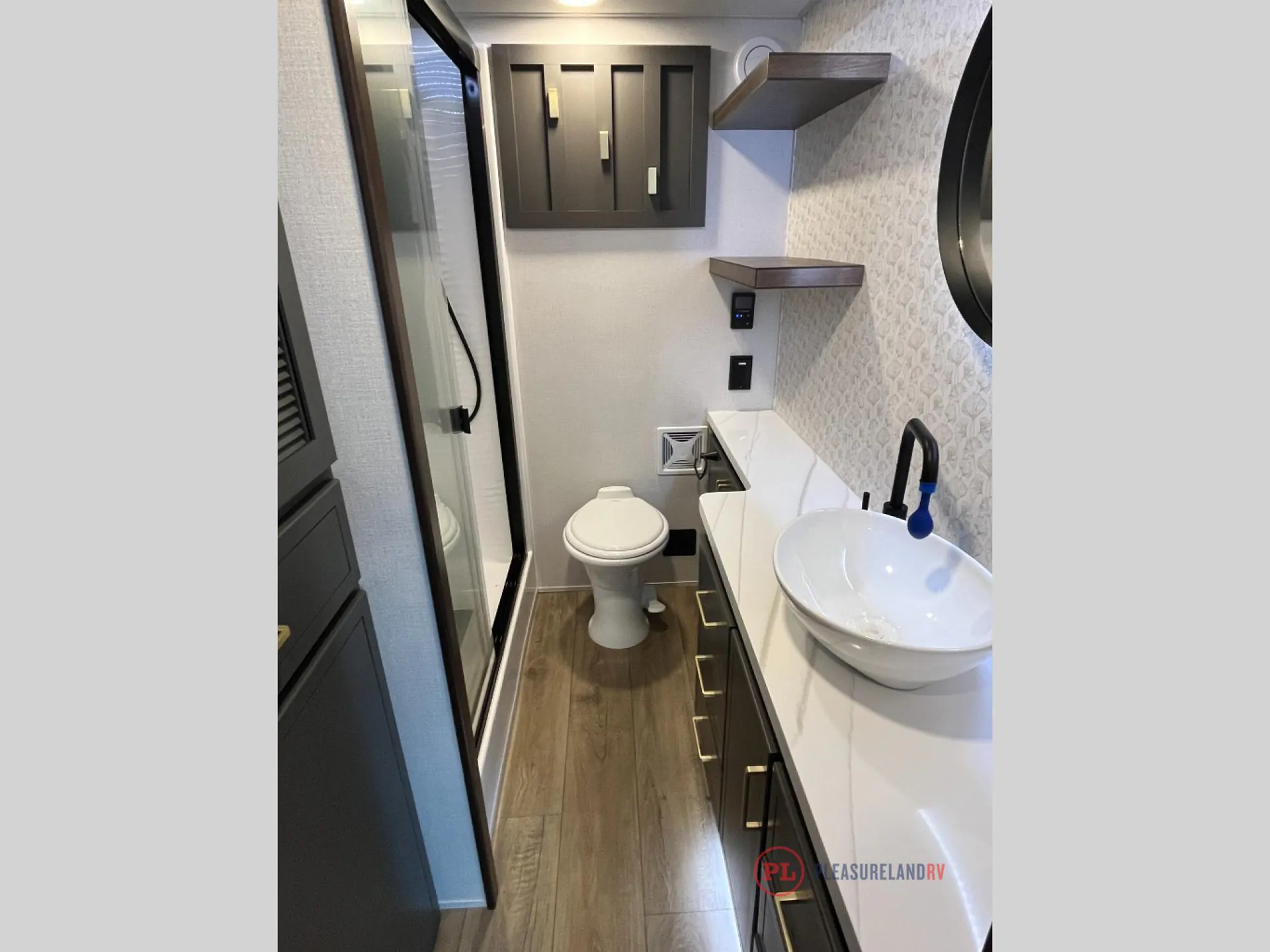 2025 Forest River Cedar Creek Cottage 41FWC — Fifth wheel bathroom with toilet, vessel sink, long vanity, cabinetry, shelves, and a shower enclosure