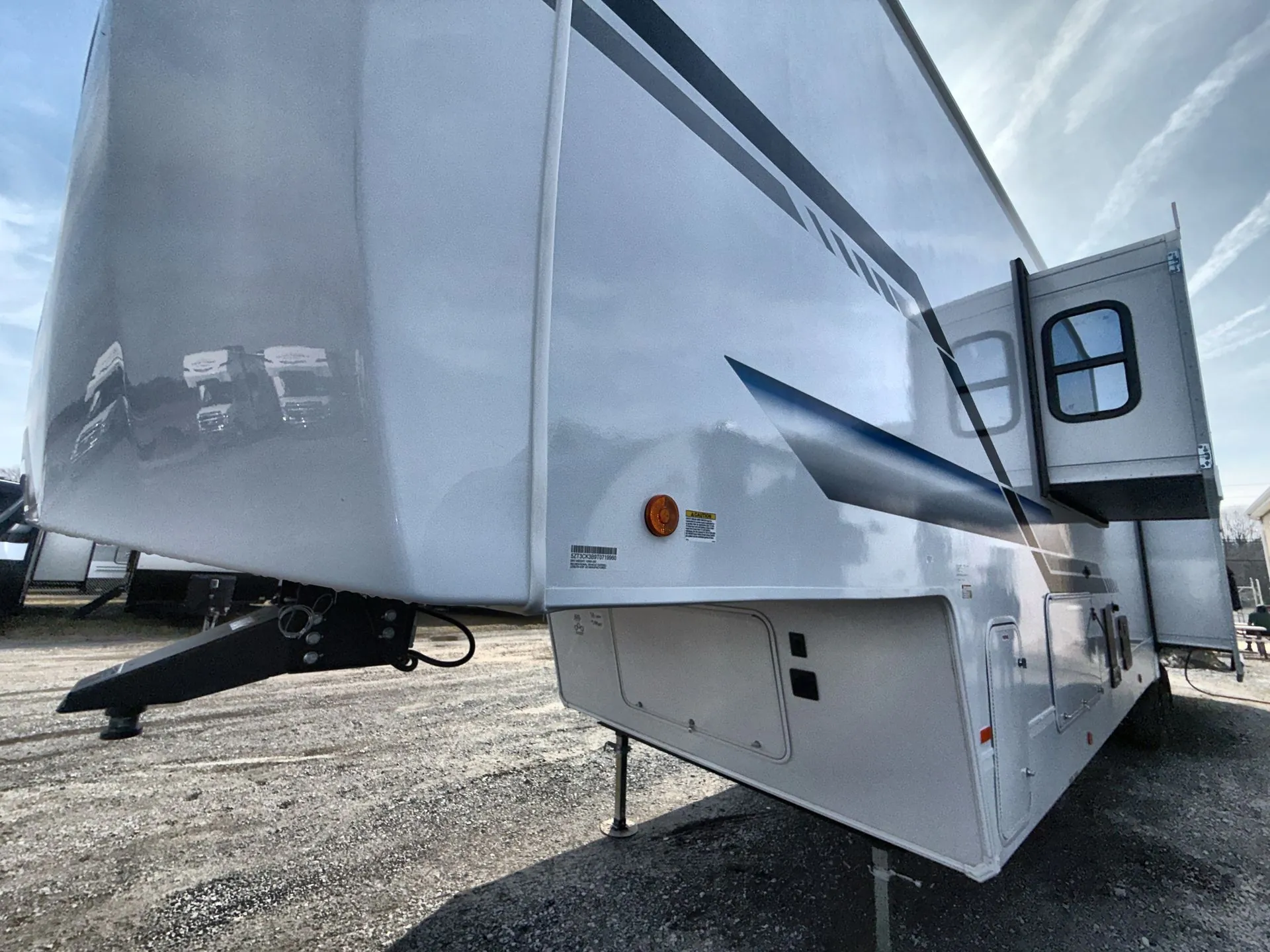 2026 Forest River Arctic Wolf 38LEAH.G — The RV's exterior front-side shell, hitch, slide-out, storage doors, and leveling equipment
