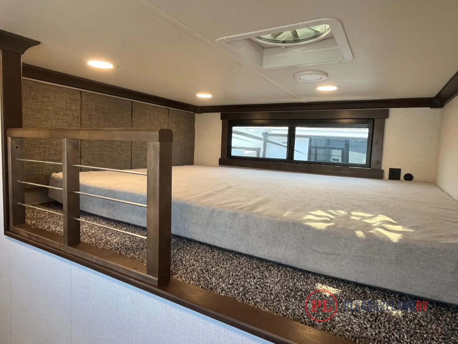 2025 Forest River Cedar Creek Cottage 41FWC — Fifth wheel bedroom with a large bed, overhead skylight, side window, and built-in shelving