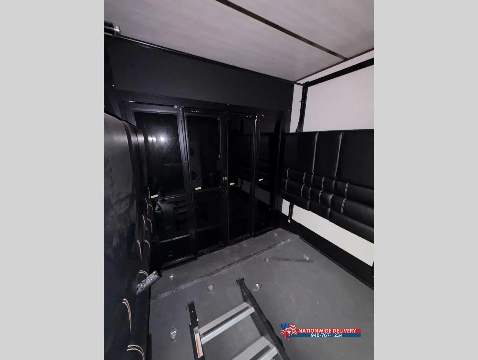 2022 Dutchmen Voltage 4225 — Toy-hauler garage with black rubber floor, wall seating, storage cabinets, and tie-down hardware