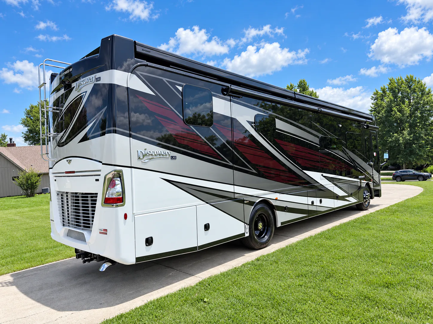 2027 Fleetwood Discovery LXE 40M — Rear three-quarter photograph visibly shows the motorhome shell, rear grille, ladder, lights, and exterior compartments