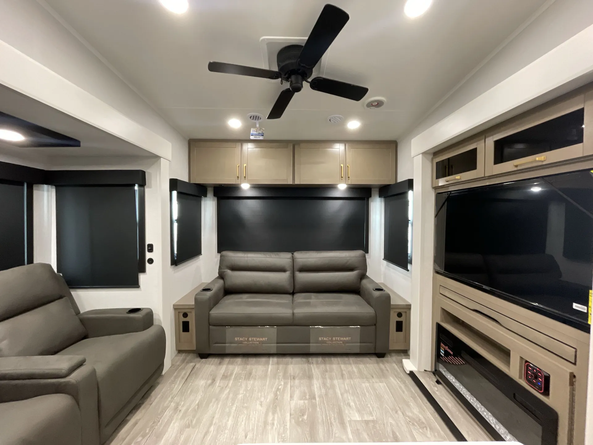 2027 Jayco Eagle 355MBQS — Fifth wheel living area with sofa, recliner, television cabinet, windows, and overhead storage
