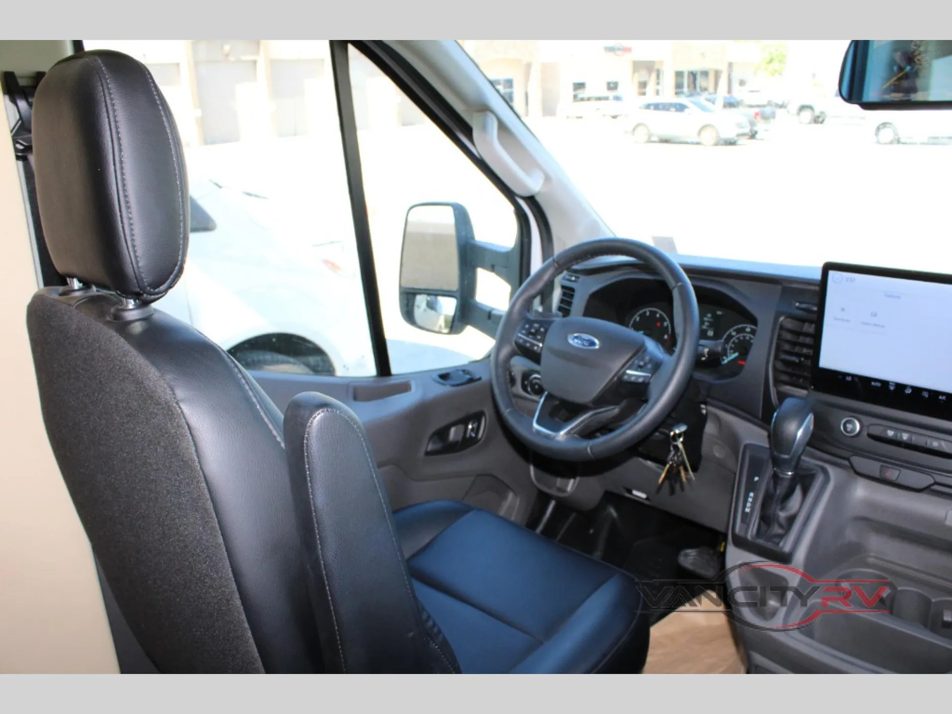 2024 Chinook RV Maverick SS — Van cockpit with steering wheel, driver seat, dashboard controls, center touchscreen, gear selector, and ignition keys