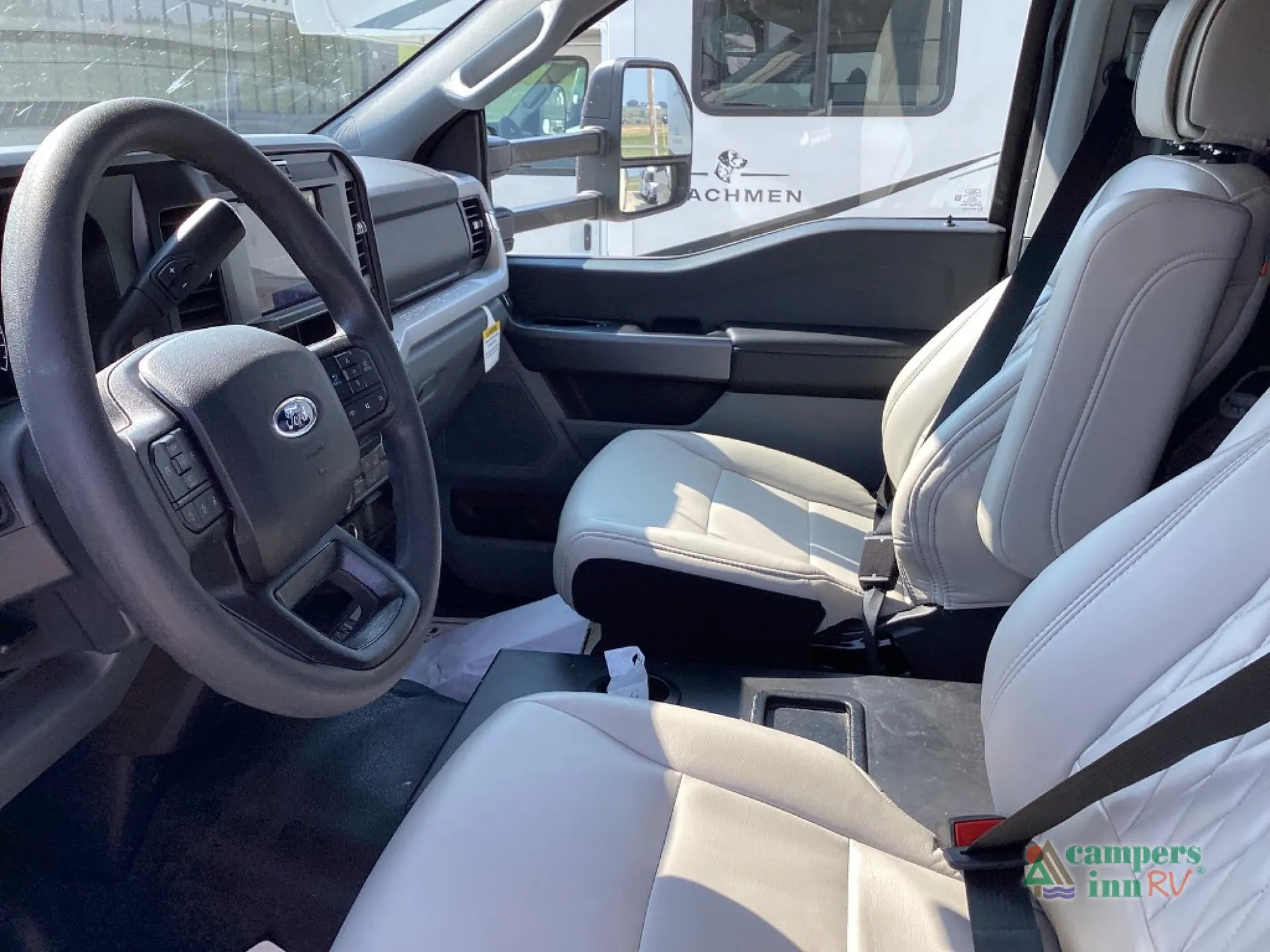 2027 Grand Design Lineage Series F 31ZW — Class C motorhome cab with steering wheel, dashboard, driver seat, passenger seat, and side window
