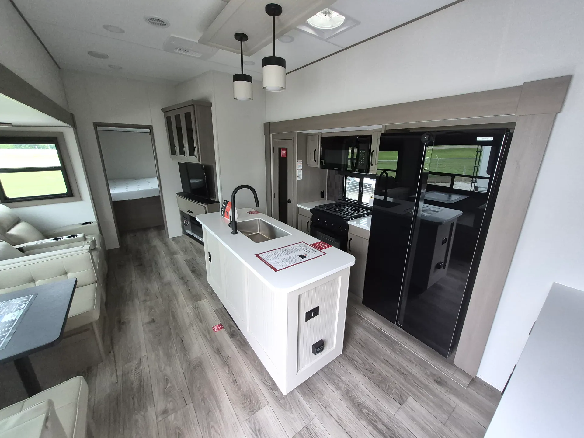 2027 Grand Design Reflection 362TBS — Fifth wheel kitchen island with sink, range, refrigerator, adjacent lounge seating, and dinette visible along the main interior