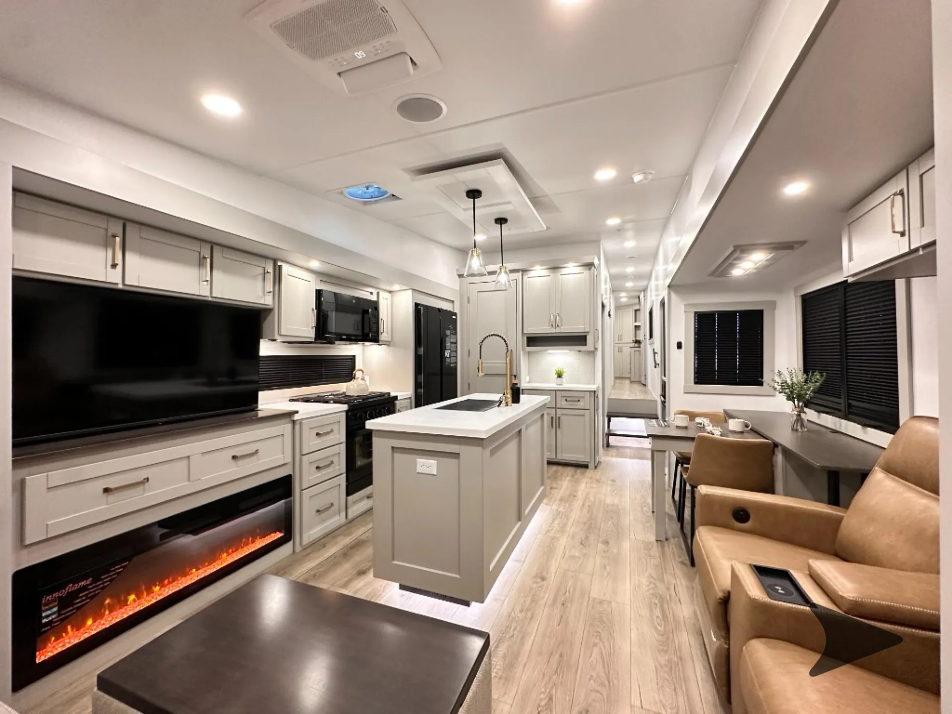 2026 Brinkley Model Z 3610 — Fifth wheel living area with recliners, television, fireplace, kitchen island, and dining table