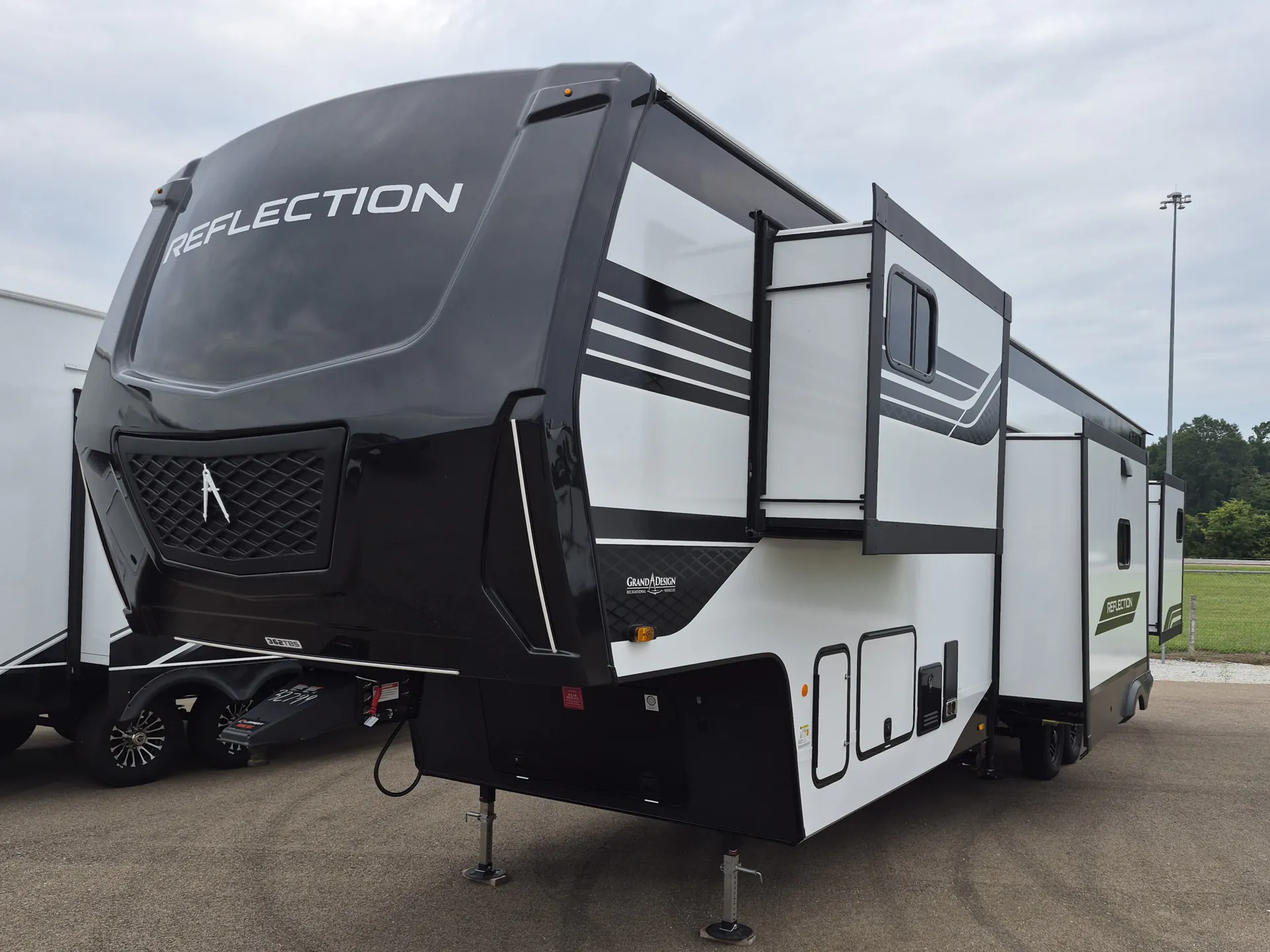 2027 Grand Design Reflection 362TBS — Photograph clearly shows the RV exterior from the front-side, including slide-outs, storage doors, and landing gear