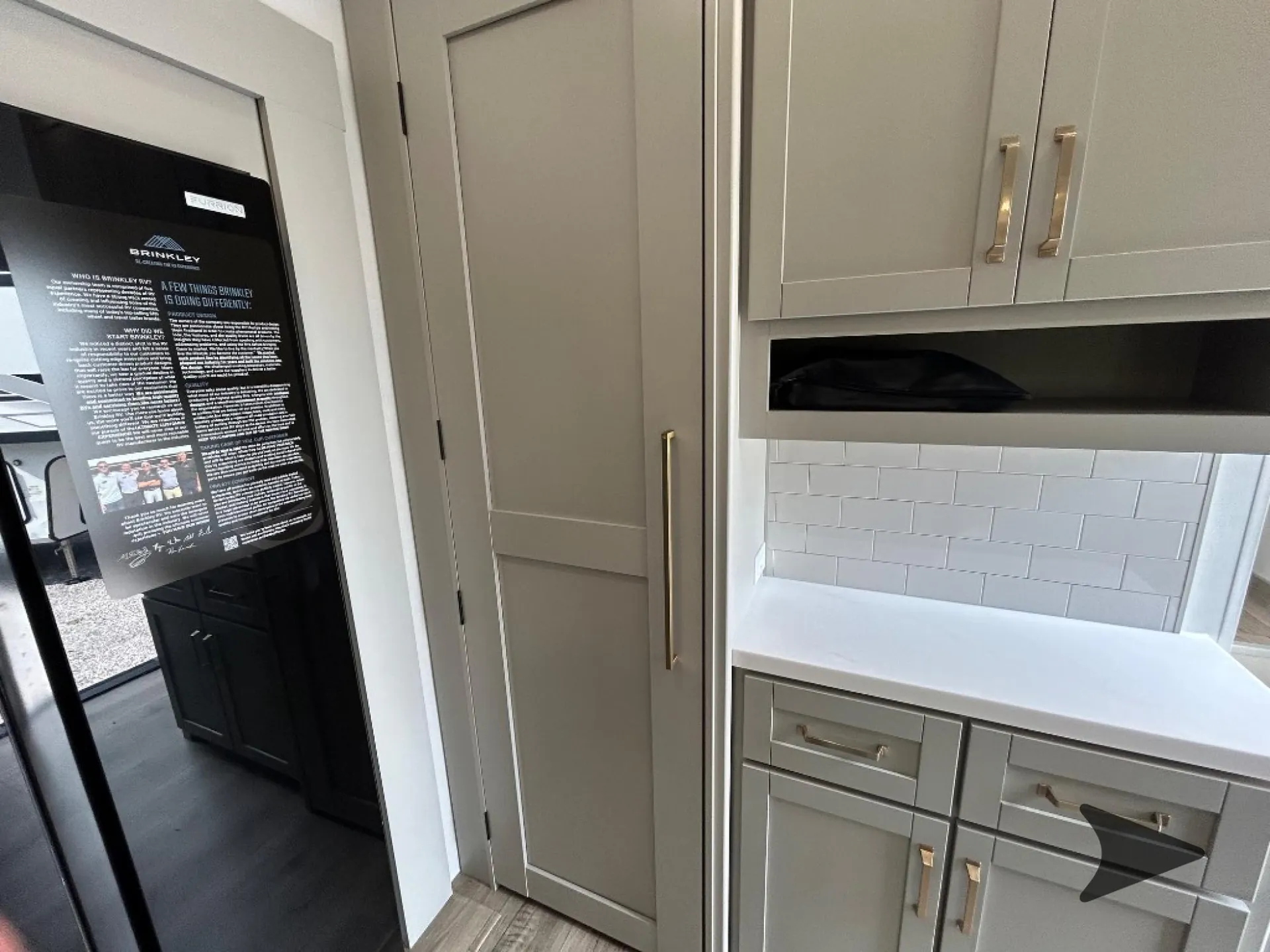 2026 Brinkley Model Z 3515 — Kitchen cabinetry and countertop beside a tall pantry door and refrigerator edge