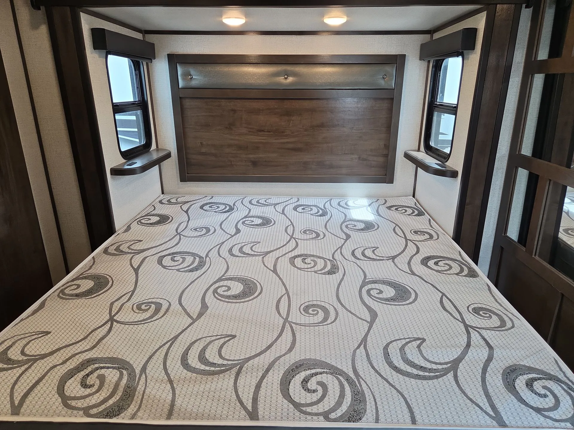 2022 Dutchmen Voltage 4225 — Fifth wheel bedroom with a full bed, padded headboard, side windows, and mirrored wardrobe door