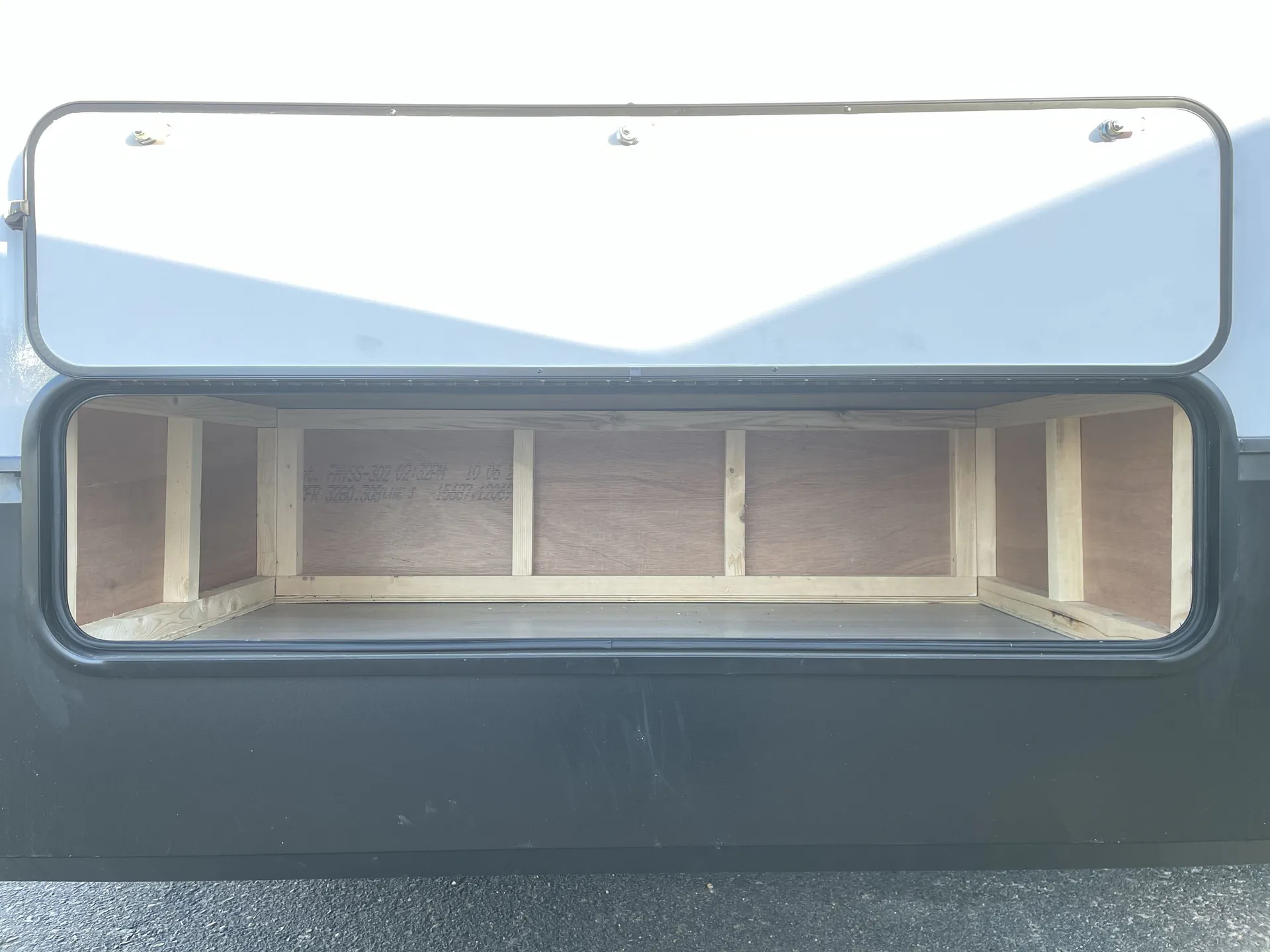 2026 Forest River Cherokee Wolf Pack 397STAY — Exterior-installed open compartment visibly shows a cargo/pass-through storage bay