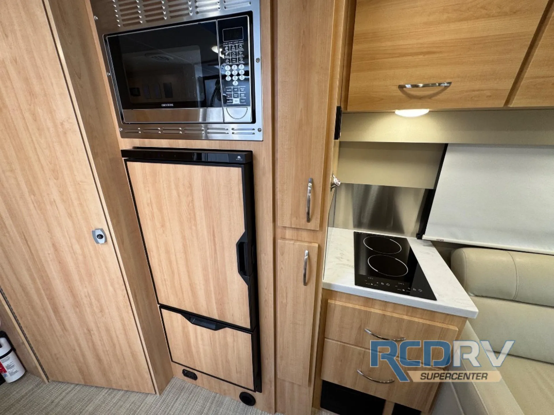 2025 Chinook RV Maverick SS — Van kitchen with microwave, refrigerator, induction cooktop, countertop, drawers, and overhead cabinets