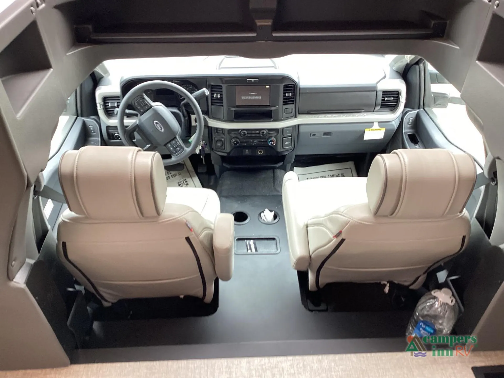 2027 Grand Design Lineage Series F 31ZW — Class C cockpit with steering wheel, dashboard controls, infotainment screen, and two captain’s chairs