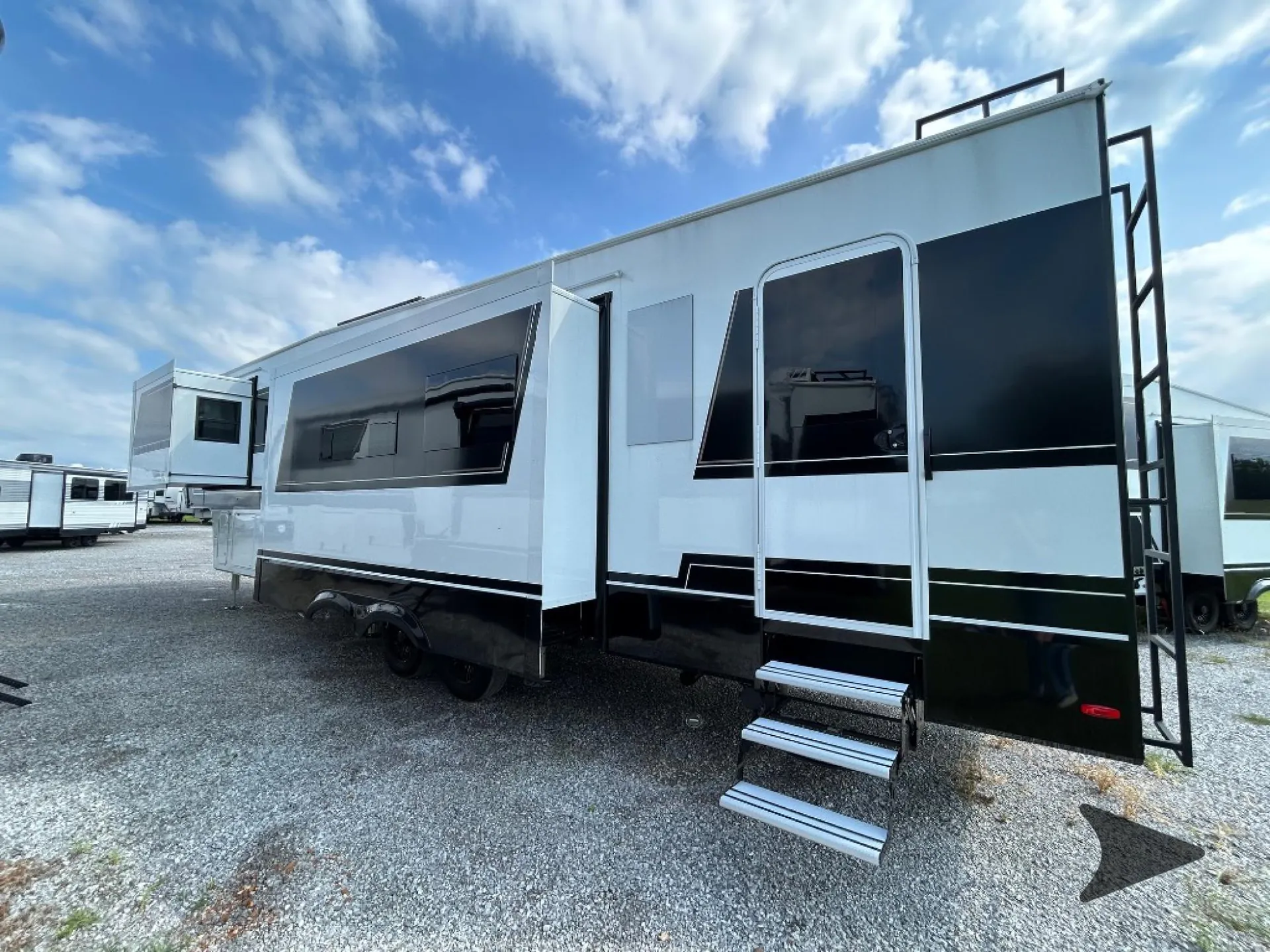 2026 Brinkley Model Z 3515 — Clear exterior side view showing the RV body, entry door, steps, windows, slide-outs, and rear ladder