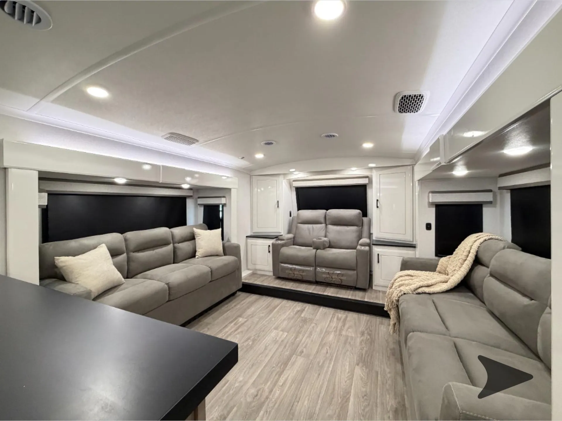 2027 Jayco Pinnacle 39FLOK — Fifth-wheel living room with sofa, opposing recliner sofa, theater seating, windows, and overhead cabinetry