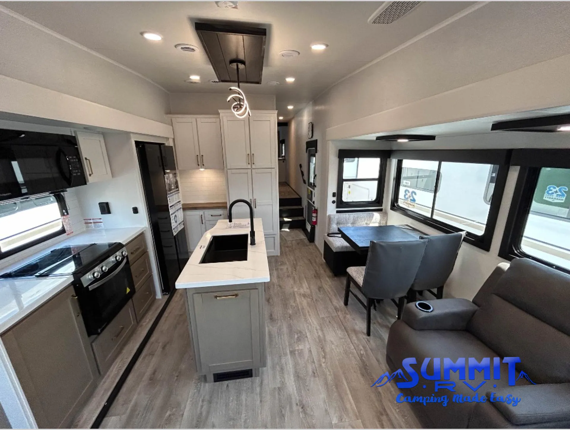 2027 Jayco Eagle 355MBQS — Fifth wheel kitchen with island sink, range, refrigerator, dinette, and sofa arranged in an open interior