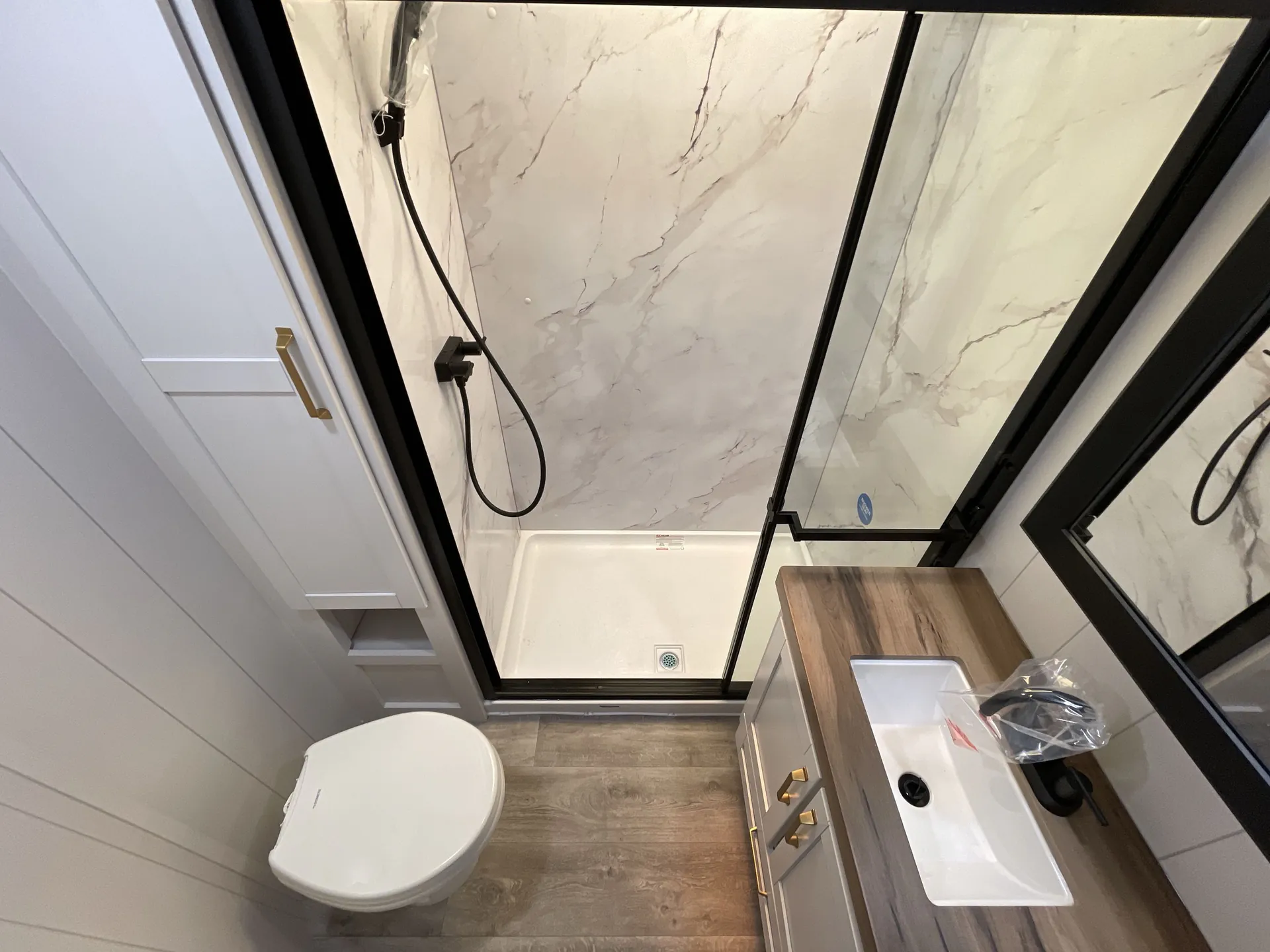 2027 Jayco Eagle 355MBQS — Bathroom with toilet, glass-enclosed shower, vanity sink, wood-look counter, and mirrored medicine cabinet