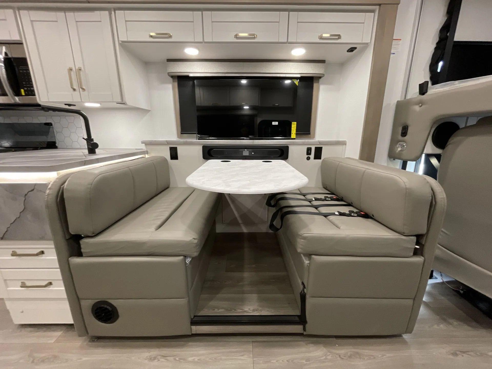 2027 Jayco Alante 29F — Dinette with two facing upholstered benches, table, overhead cabinets, and adjacent kitchen counter and sink