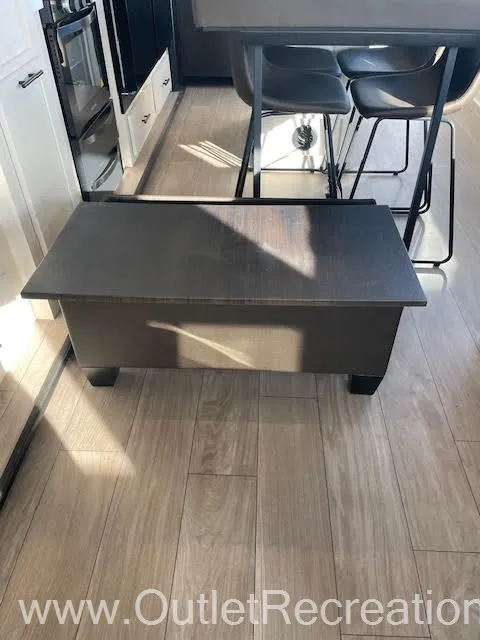2026 Forest River Arctic Wolf 38LEAH.G — Fifth wheel kitchen island beside a counter with bar stools and visible oven cabinetry in the adjacent kitchen