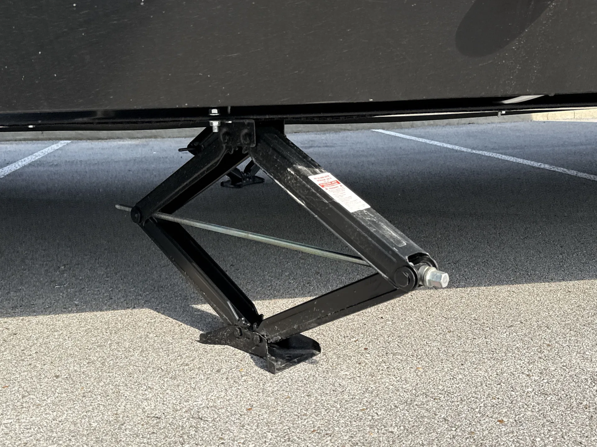 2026 Grand Design Foundation 42GD — Close photograph of an exterior-installed scissor stabilizer jack beneath the RV